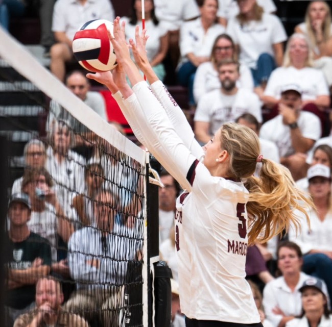 AHS vball team blocking a shot