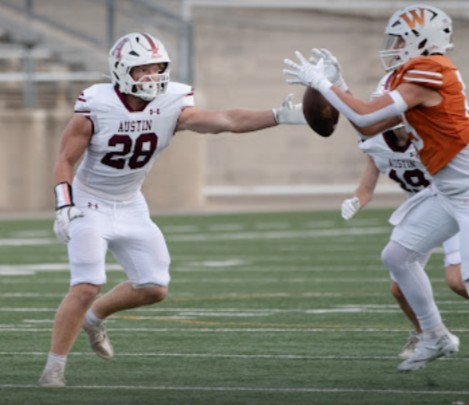 Austin High football player on Maroons team playing defense.