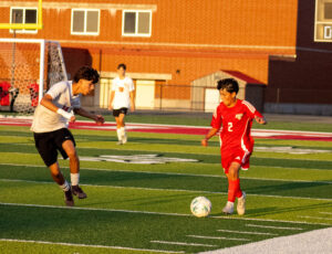 KC boys soccer player dribbles past Grant defender.