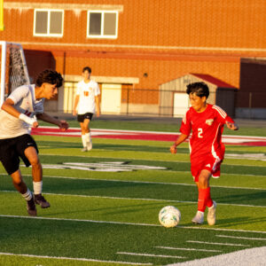 KC boys soccer player dribbles past Grant defender.