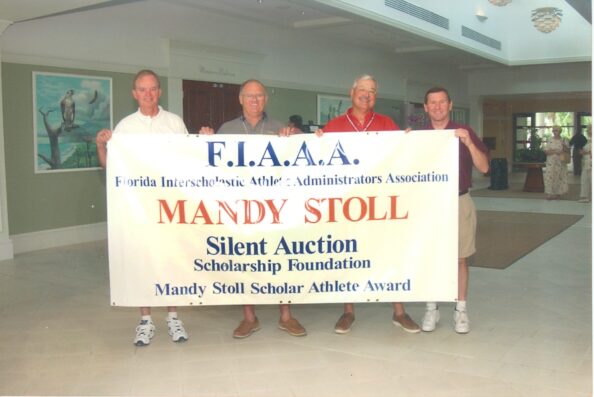 Tommy St. Amant, Charlie McBride, Tom Stoll and Ronnie Youngblood display the Silent Auction Banner