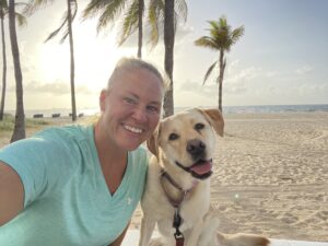 Coach Johnson on the beach with her dog Molly