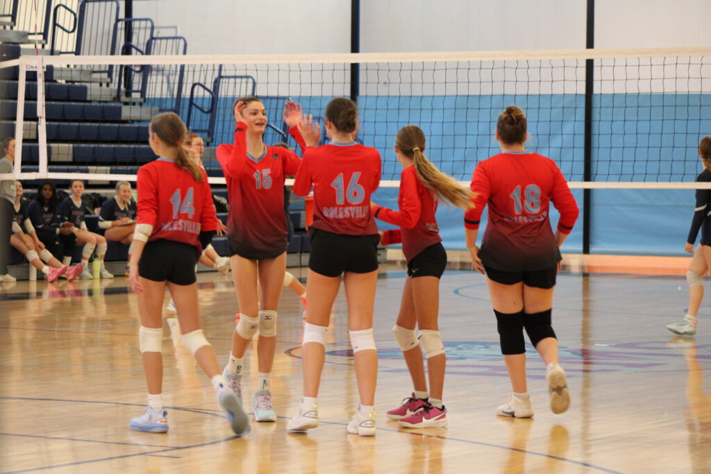 5 volleyball players celebrating a winning point