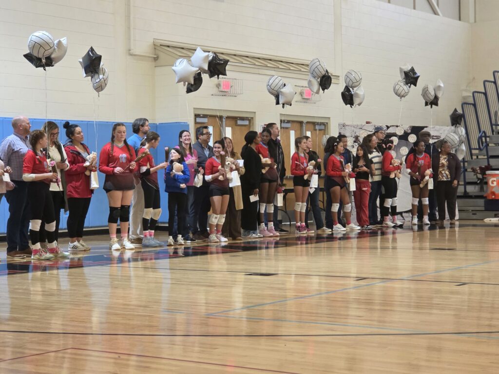 Students standing with their parents before a game.