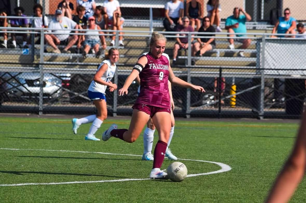 Female soccer player kicking ball