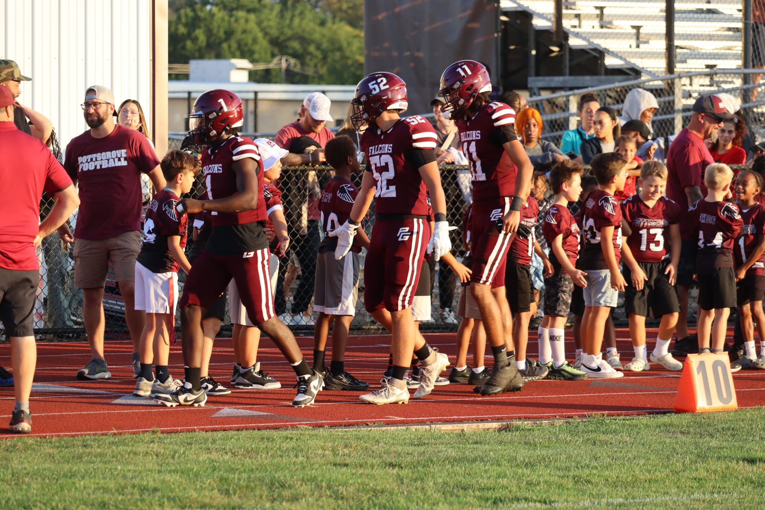Football players high-fiving kids