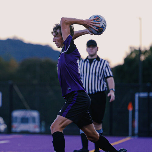 Soccer player readies themselves to throw in a soccer ball