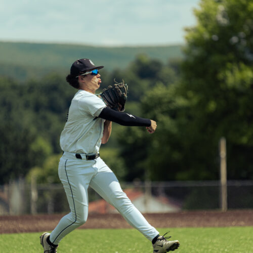 Baseball player about to catch a baseball on a field