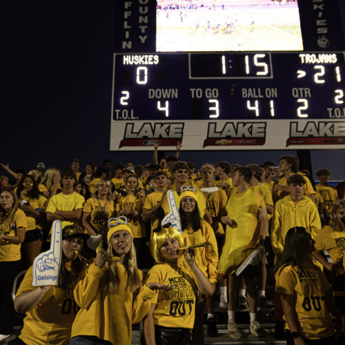 Students in bleachers cheer on the Mifflin County Huskies while dressed in all gold.