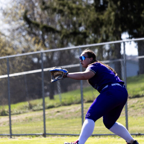 Softball player has their glove out to catch the ball