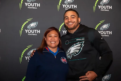 Mastbaum Athletics Director Antoinette Calimag poses with Philadelphia Eagles Linebacker and Temple University Alumni, Shaun Bradley