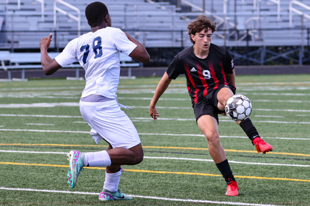 soccer player kicking ball off ground