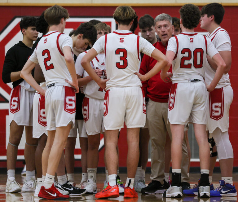 Boys basketball team in huddle.