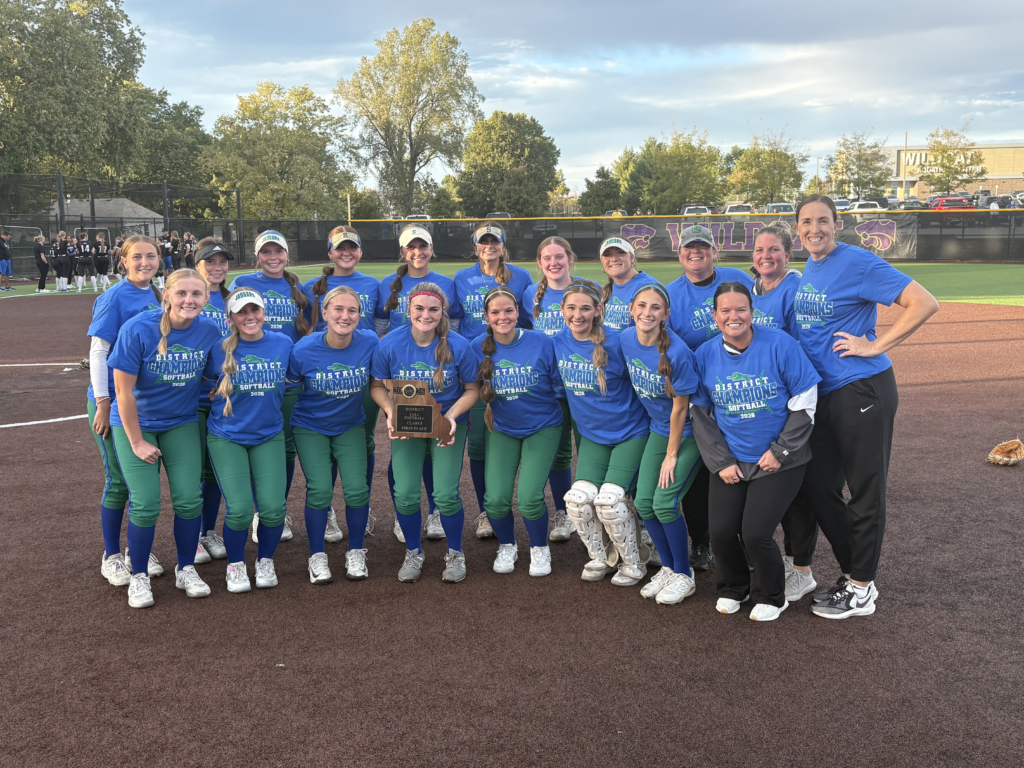 softball team photo posing in district champion shirts. 