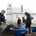 Quince Orchard varsity soccer team participates in an event at the Pleasant View Historical Site where they learned some of the history of the church and one-room school house as well as did clean-up of the grounds and helped reset furniture in the historic one-room school house	.