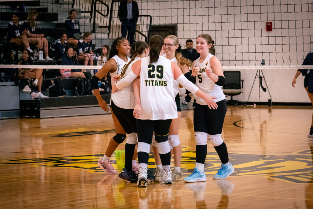 The St. Bernard-Elmwood Place girls volleyball team smile together after scoring.
