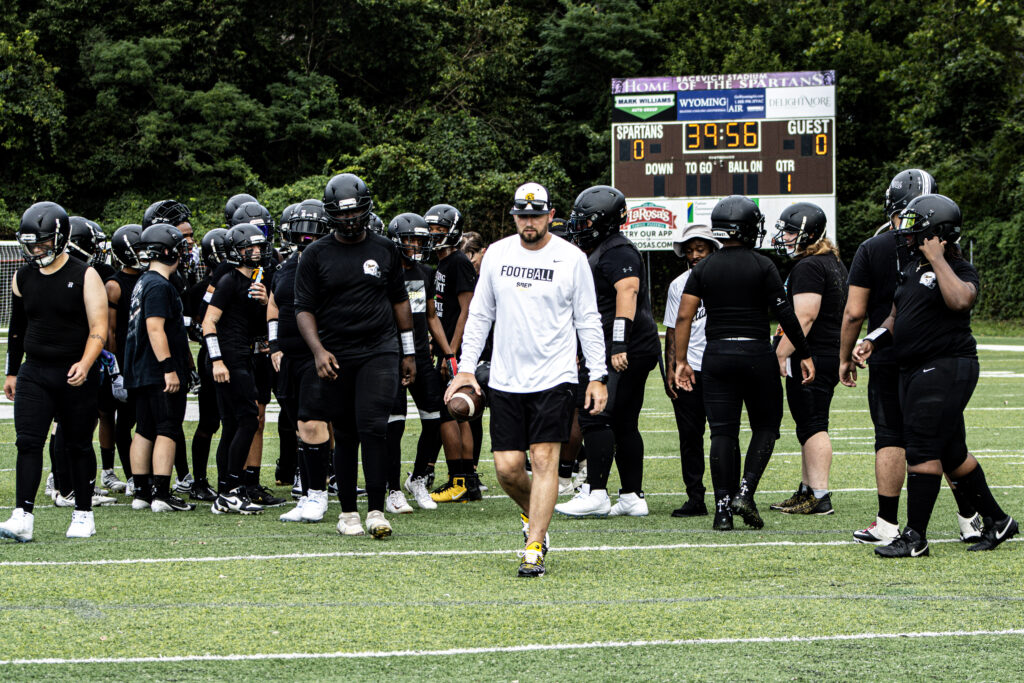 SBEP head football coach Kyle Hogan leads the football team as they walk down the field.