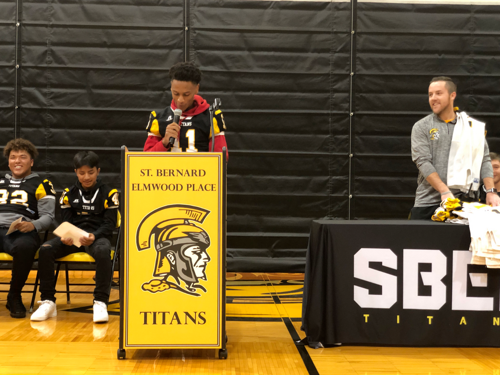An SBEP student stands to speak at a podium.