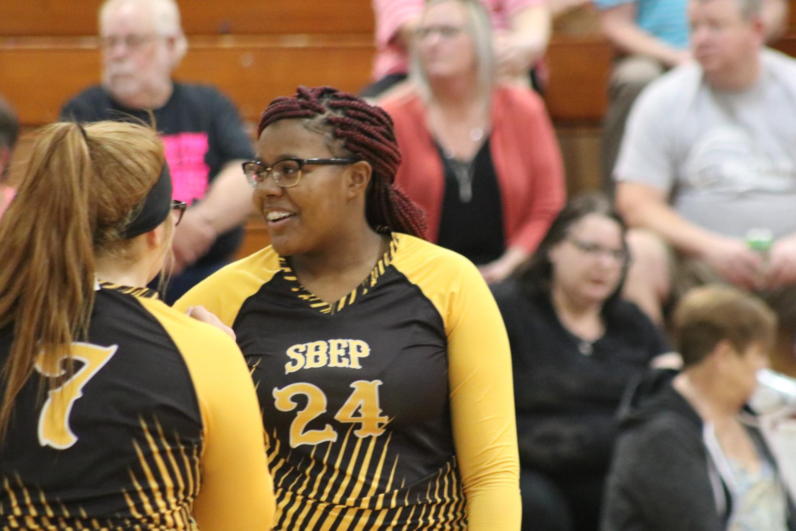 An SBEP volleyball player smiles while looking off camera.