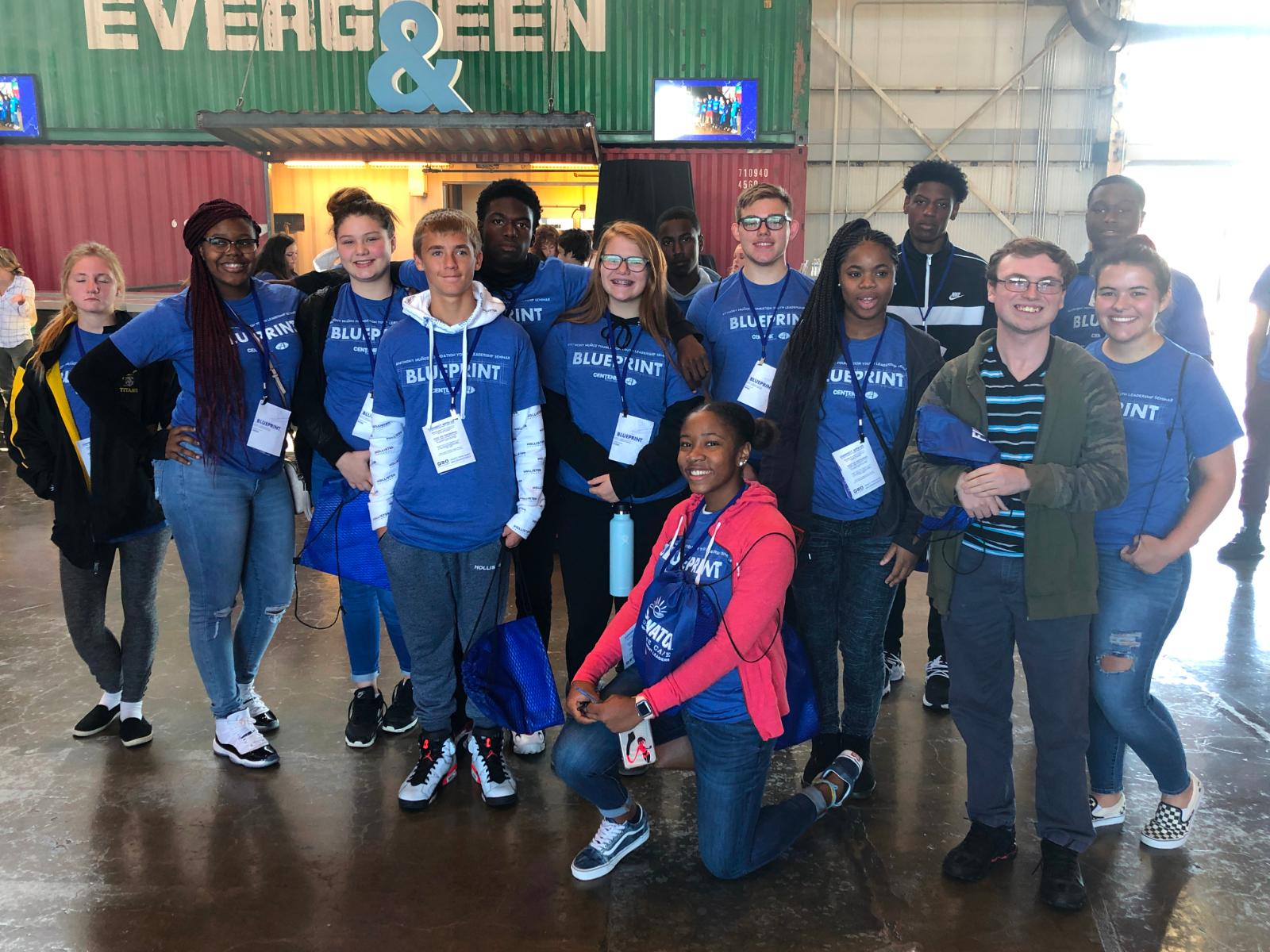 A group of SBEP students pose for a photo while wearing shirts that read "Blueprint."
