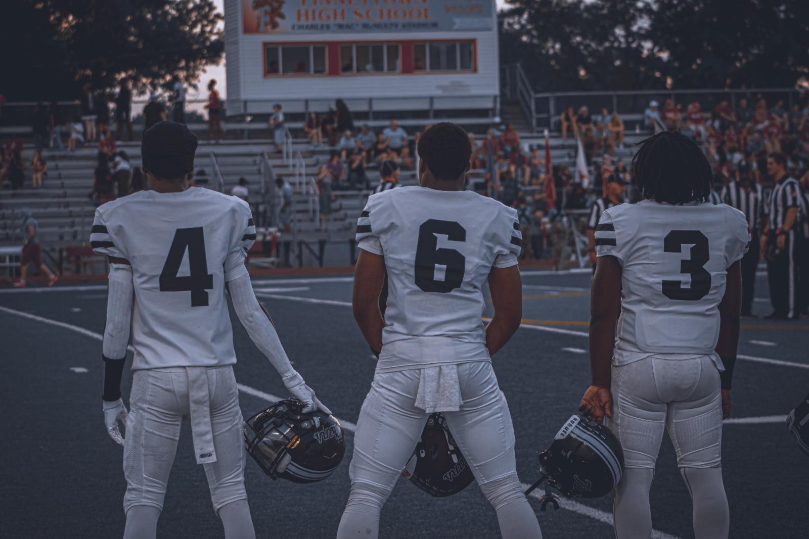 SBEP football players stand beside each other before a game.