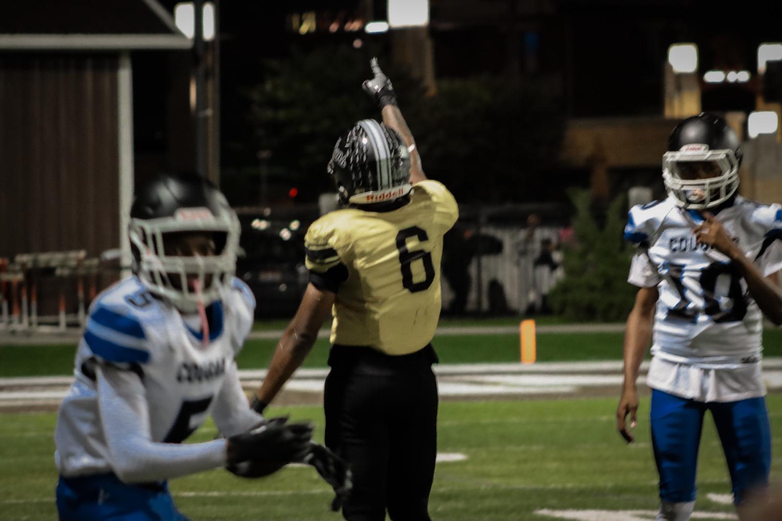 After a big play, an SBEP football player points at the sky.