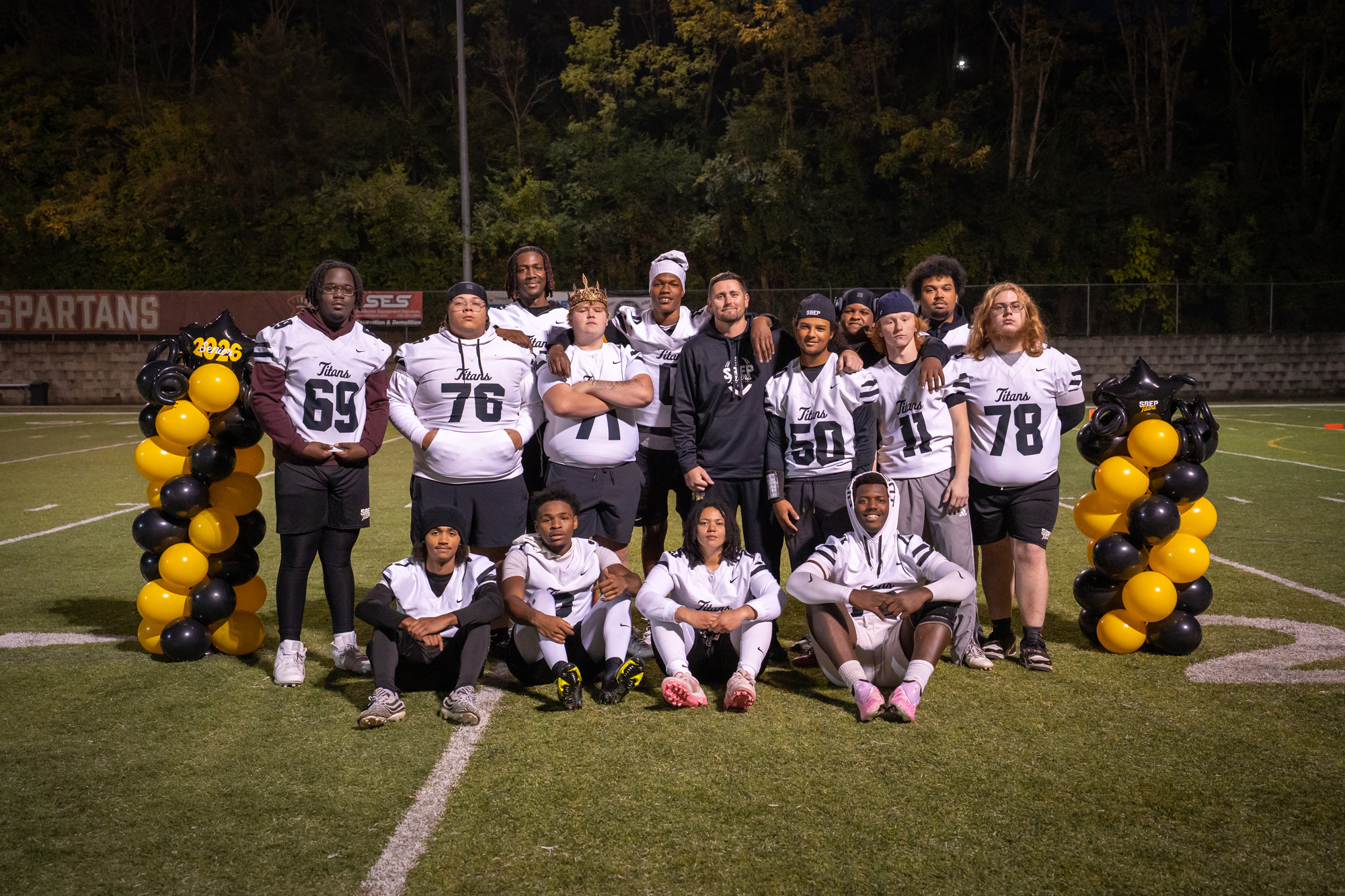 Head coach Kyle Hogan poses with the senior members of the football team.