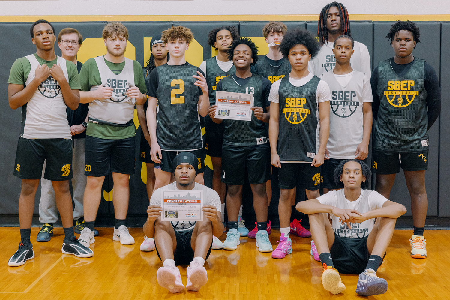 The SBEP boys varsity basketball team poses for a photo. Two players in the middle of the photo are holding a certificate for top Ohio small-school team of the week from The Cincinnati Enquirer.