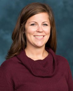 A woman smiles for a portrait picture.