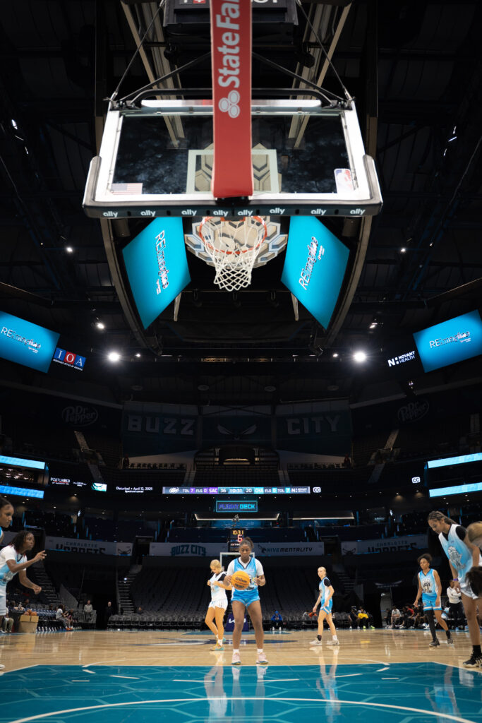 Girl preparing to shoot a basketball with teammates nearby. 