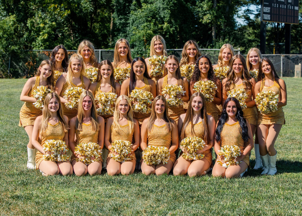 two rows of girls in gold dance costumes lined up for a team picture.