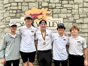Five boy golfers standing in front of a stone wall at Oak valley golf course and resort.