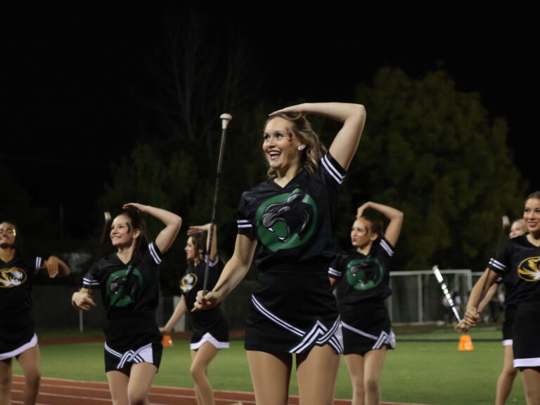 girls with a baton performing at a football game