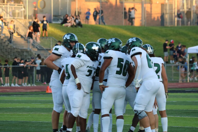 Football players in a huddle between plays