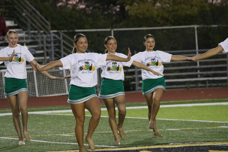 four girls dancing on the football team at halftime