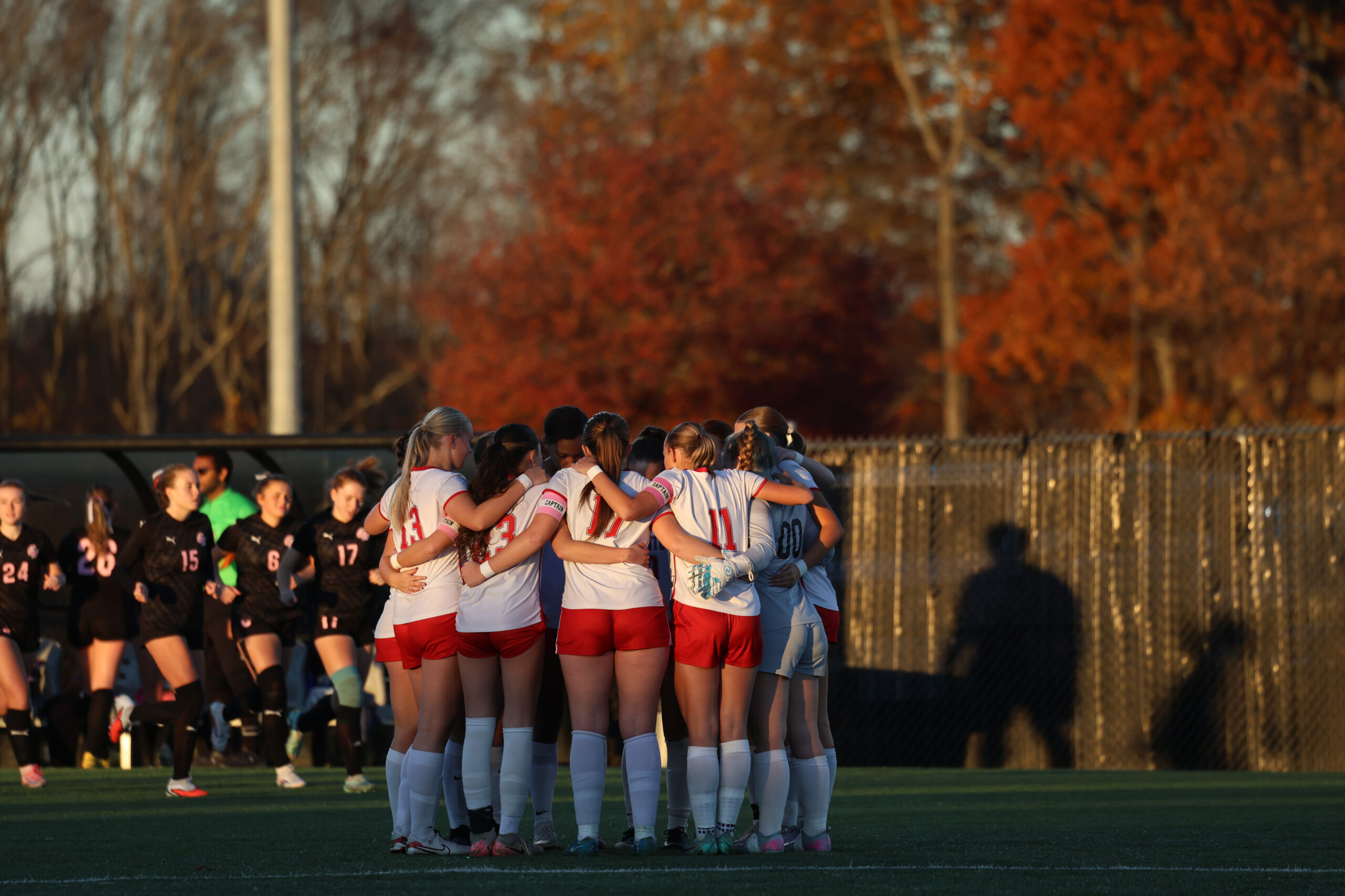 A girls soccer team huddling.