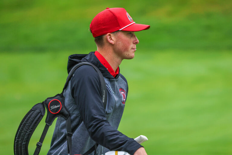 Golfer carrying his clubs.