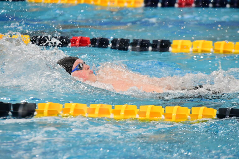 Swimmer from GW doing backstroke.