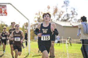 A cross country runner in black with a W on his chest.