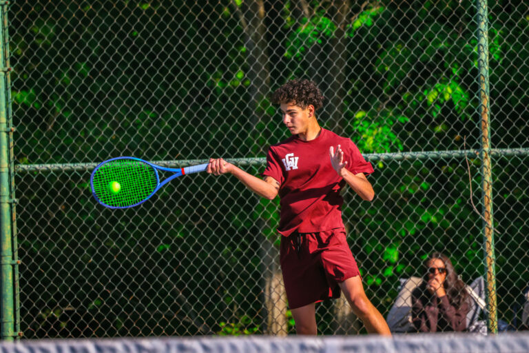 A high school athlete playing tennis.