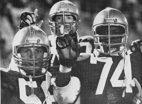Football players in uniform hold up index fingers for No. 1