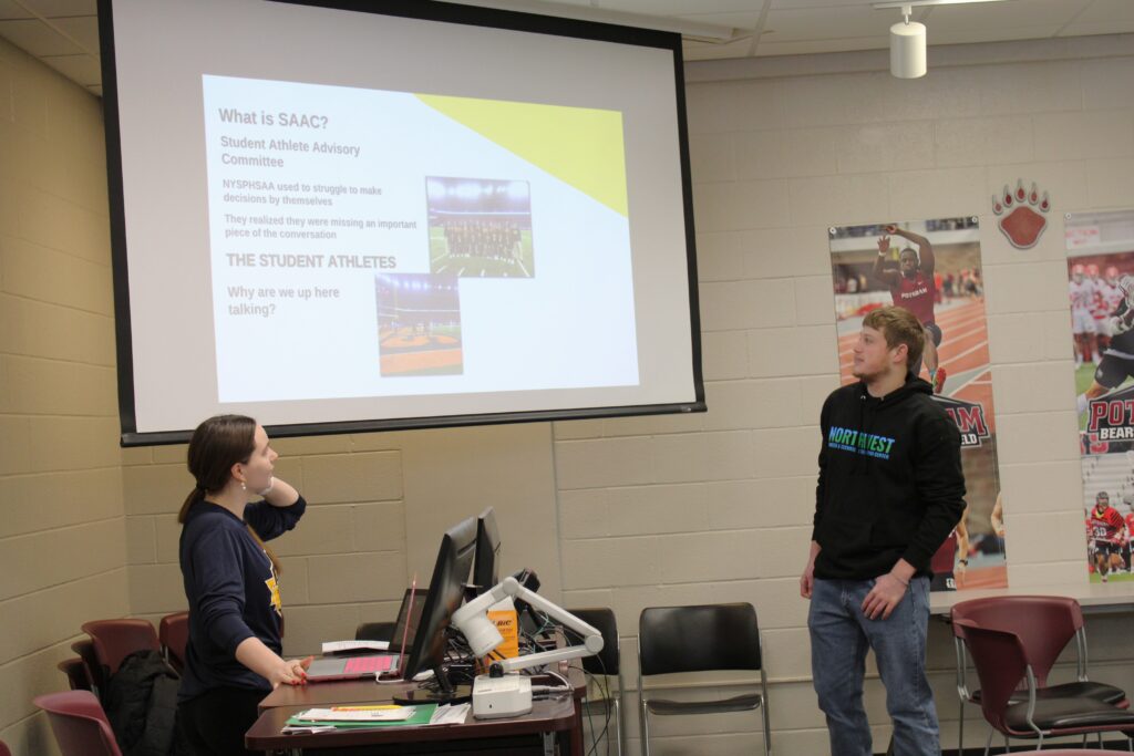 A female and a male high school student giving a presentation