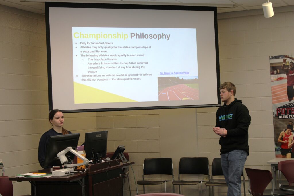 A female and a male high school student making a presentation