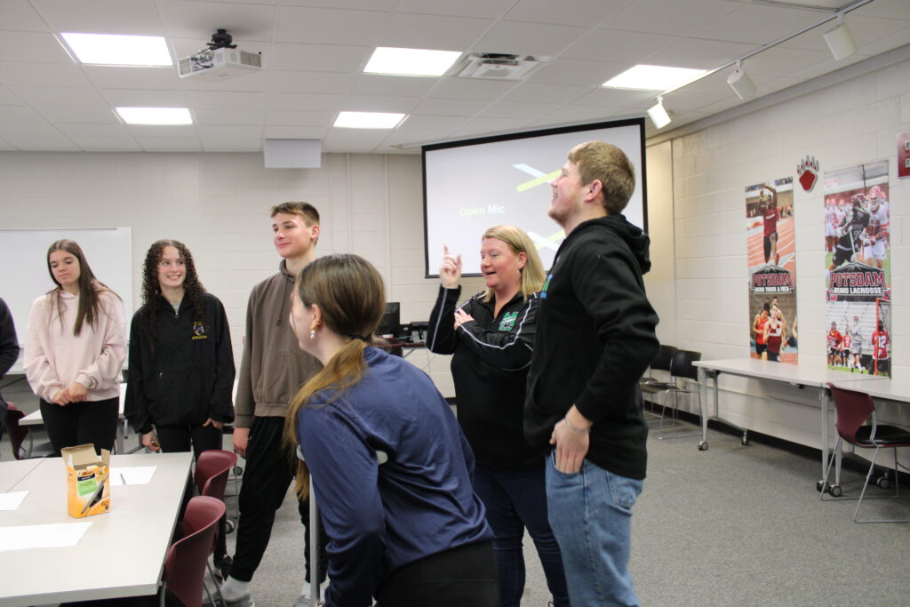 Small group of high school students and adult female having conversation