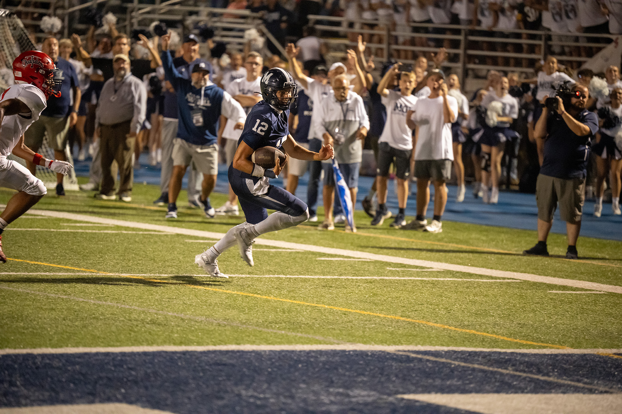 Evan Kuhn running with the ball on the field during the McDowell vs. Chardon varsity football game.