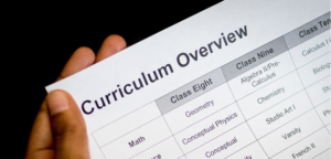 Image shows a hand holding a document that reads Curriculum Overview
