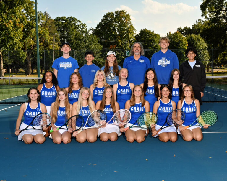Girls varsity tennis tennis dressed in tennis skirt and blue tops