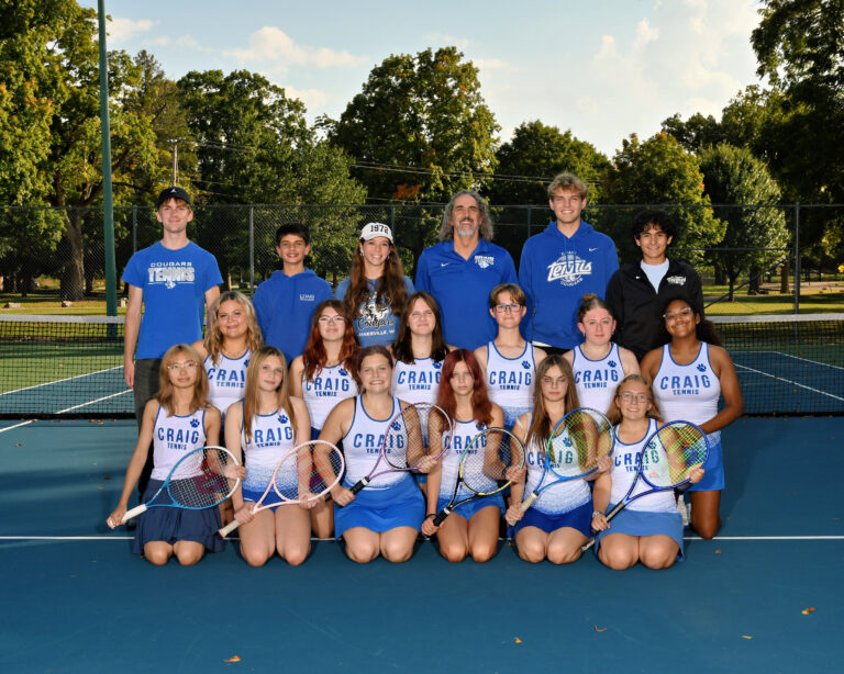 JV girls tennis team in tennis skirts and white tops