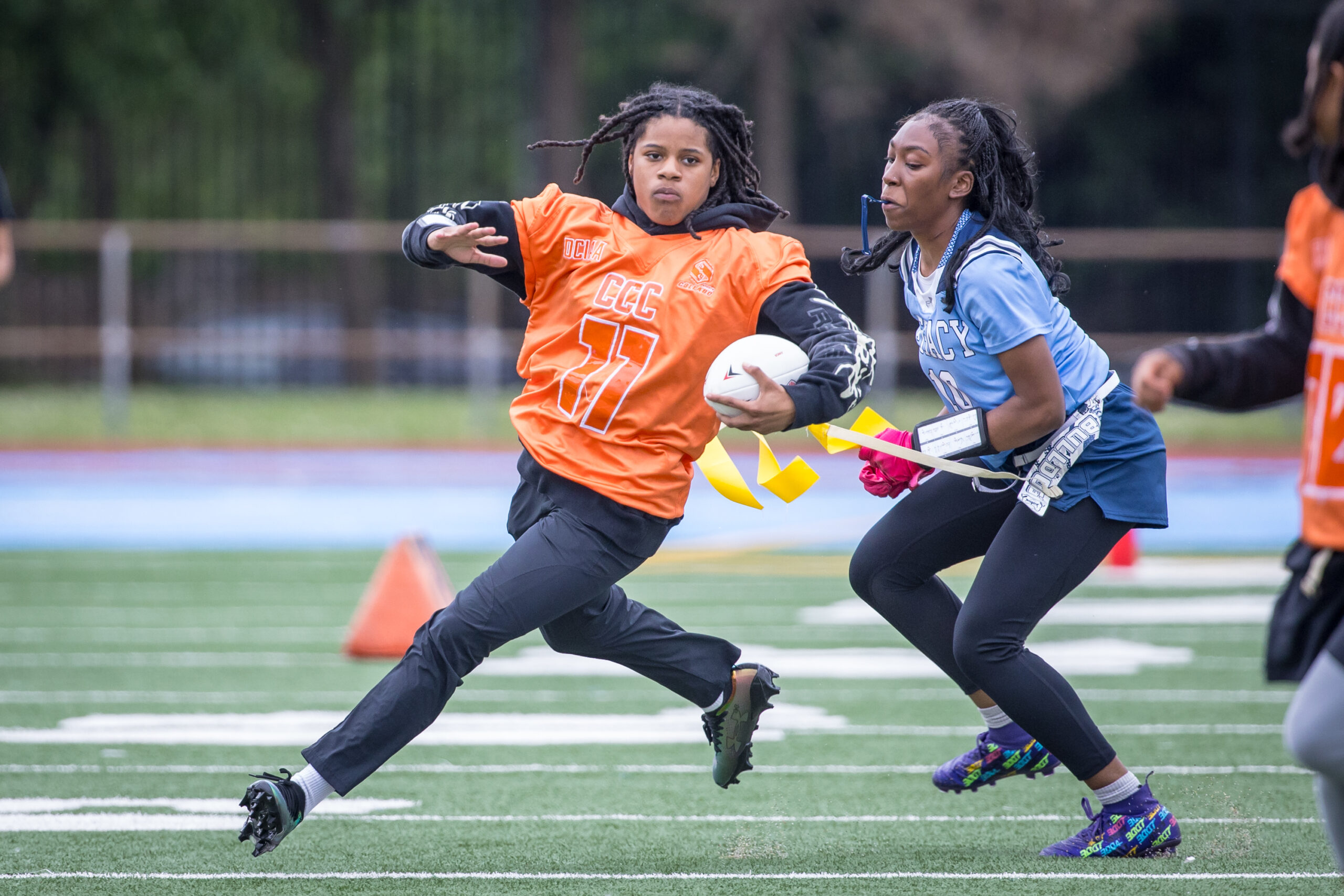 Girl running with ball away from opposing player.