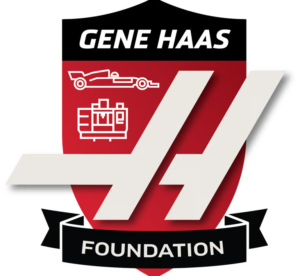 Red and black shield logo for the Gene Haas Foundation featuring white stylized car and machine icons, "Haas" text, and "Foundation" banner.